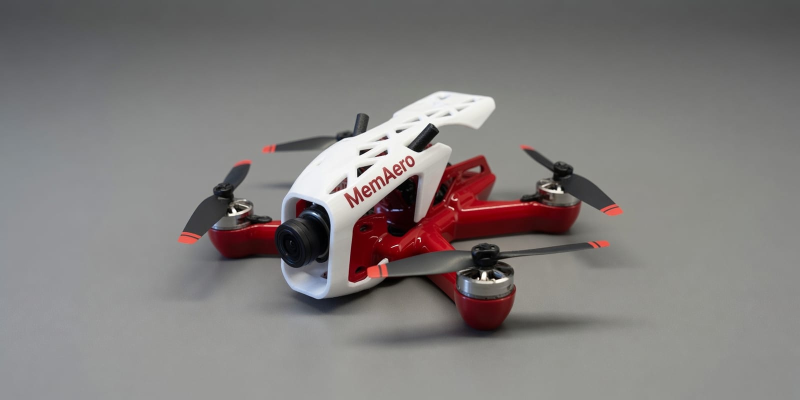 MemAero Aero 2 5-inch FPV freestyle drone — red and white airframe with 3D-printed white canopy, 3/4 front-left view (design render)